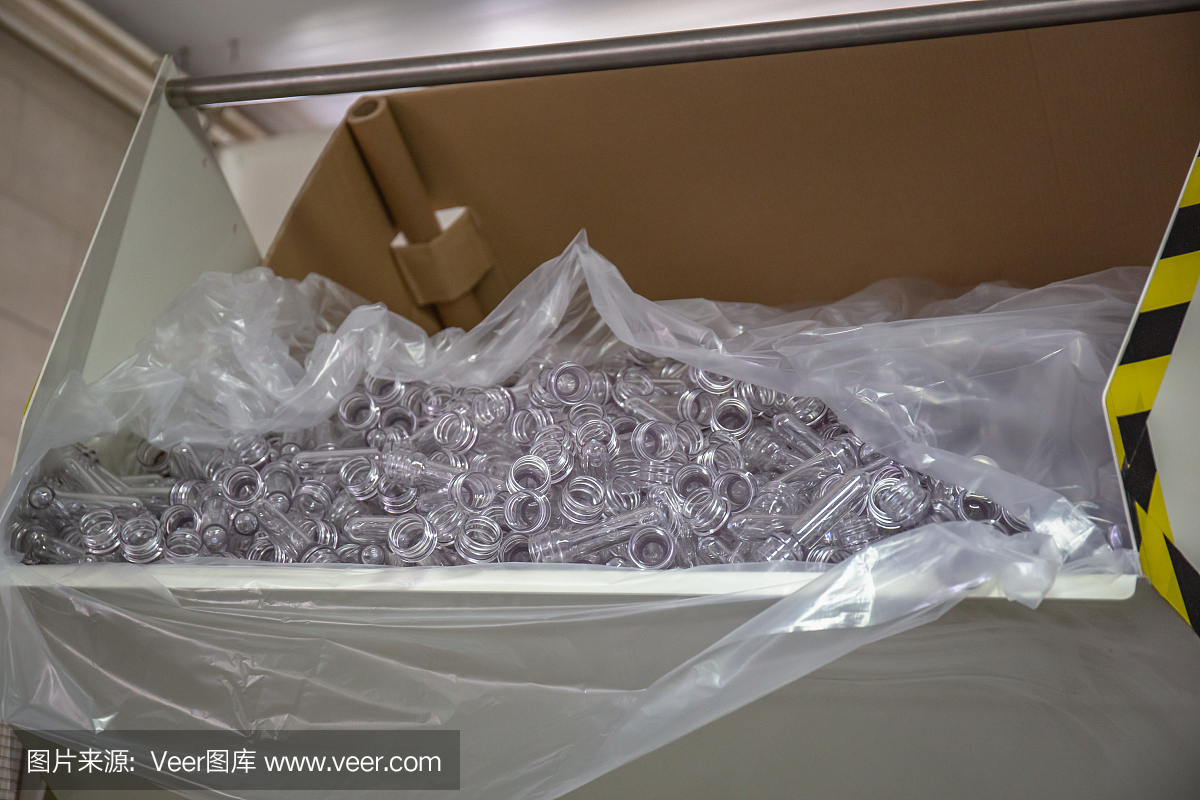 在果汁和水廠生產的傳送帶工業機器上用于吹制容器中的塑料瓶的許多PET預成型件